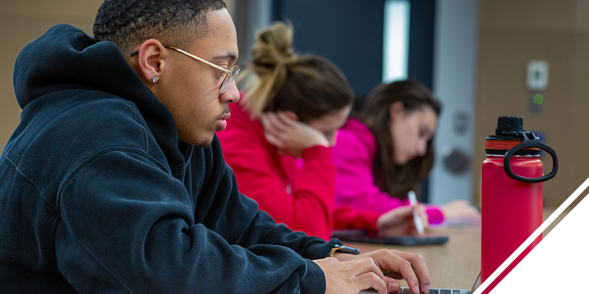 Student typing on a personal laptop.