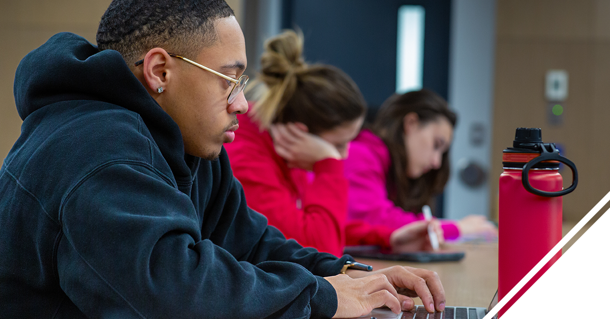 Student typing on a personal laptop.